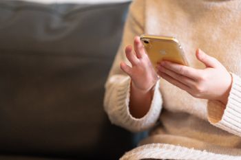 Student on her mobile phone with access to online support functions at the University of Hertfordshire