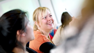 A female postgraduate Hertfordshire International College student smiling in class
