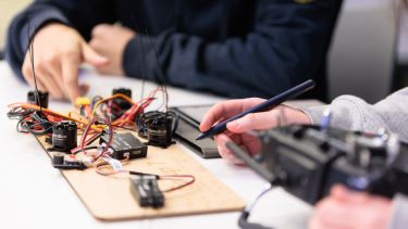 Two students working with computer hardware in computer science class