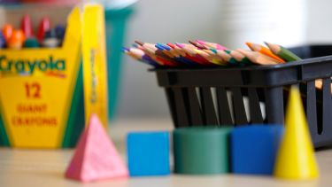 a desk with colouring pencils and crayons