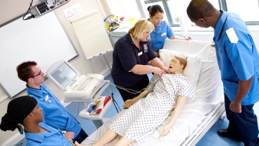 Nursing students having practical lesson on treating patients