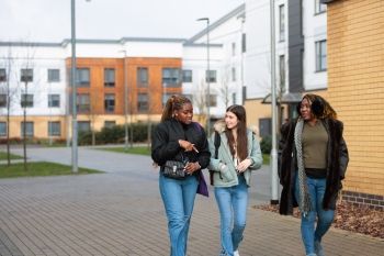 Three female undergraduate students walking together on campus