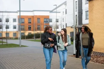 Three female undergraduate students walking together on campus