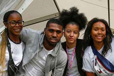 Four students standing arm in arm looking towards the camera