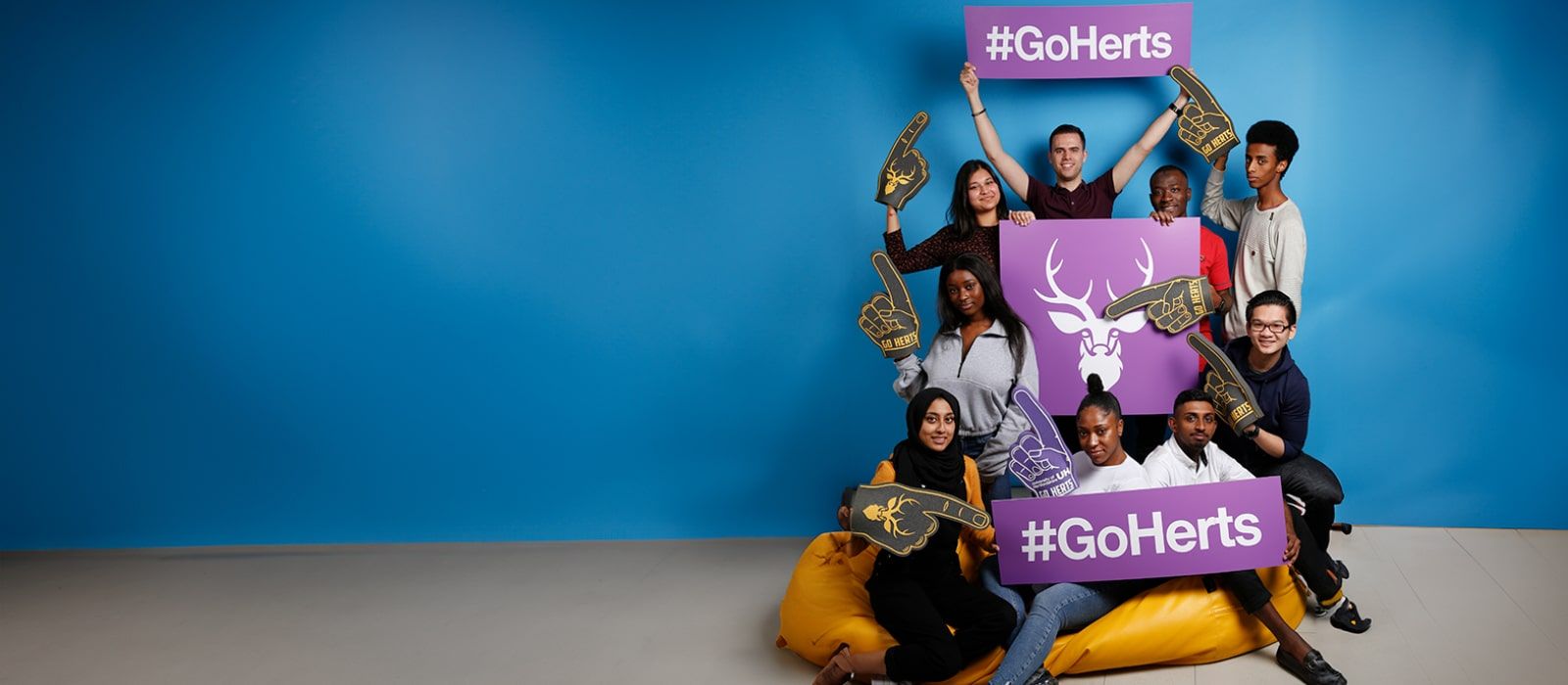 A group of people holding a GoHerts Sign